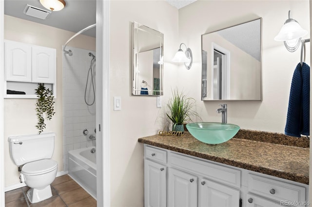 full bathroom featuring vanity, tile patterned floors, toilet, and tiled shower / bath