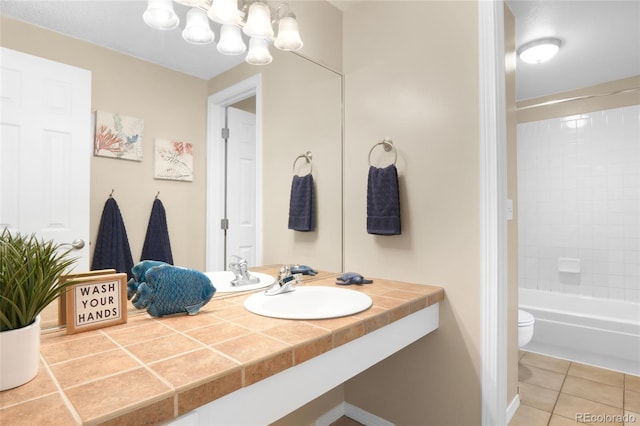 full bathroom with sink, toilet, tiled shower / bath, and tile patterned flooring