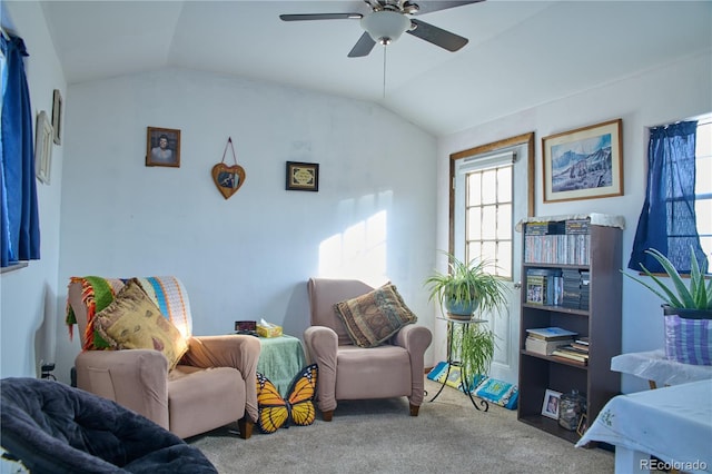 living area featuring ceiling fan, carpet flooring, and vaulted ceiling