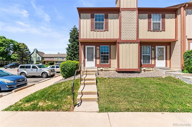14465 E Hawaii Cir Unit A, Aurora, CO 80012 - townhome / multi-family property with uncovered parking, a front lawn, board and batten siding, and entry steps