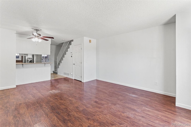 14465 E Hawaii Cir Unit A, Aurora, CO 80012 - unfurnished living room featuring a ceiling fan, stairs, wood finished floors, baseboards, and a textured ceiling