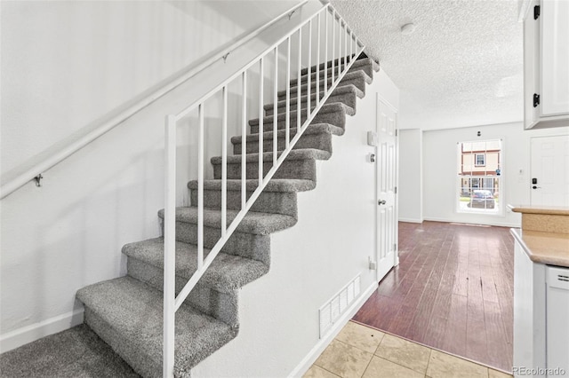 14465 E Hawaii Cir Unit A, Aurora, CO 80012 - stairway featuring baseboards and a textured ceiling