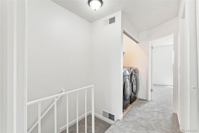 14465 E Hawaii Cir Unit A, Aurora, CO 80012 - laundry room featuring washing machine and dryer, a textured ceiling, carpet, and baseboards