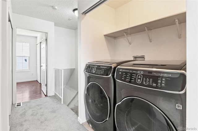 14465 E Hawaii Cir Unit A, Aurora, CO 80012 - laundry area with washer and clothes dryer, carpet floors, a textured ceiling, and baseboards
