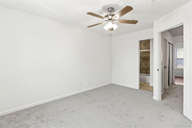14465 E Hawaii Cir Unit A, Aurora, CO 80012 - unfurnished bedroom featuring light colored carpet, a textured ceiling, baseboards, ensuite bath, and a ceiling fan
