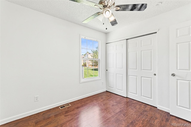 14465 E Hawaii Cir Unit A, Aurora, CO 80012 - unfurnished bedroom with dark wood-type flooring, baseboards, a closet, a textured ceiling, and ceiling fan