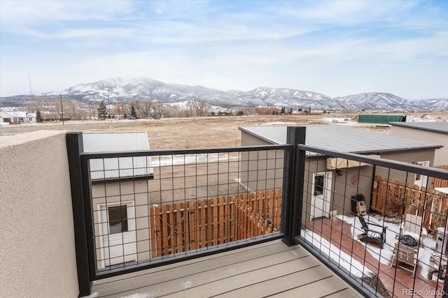 snow covered back of property featuring a mountain view