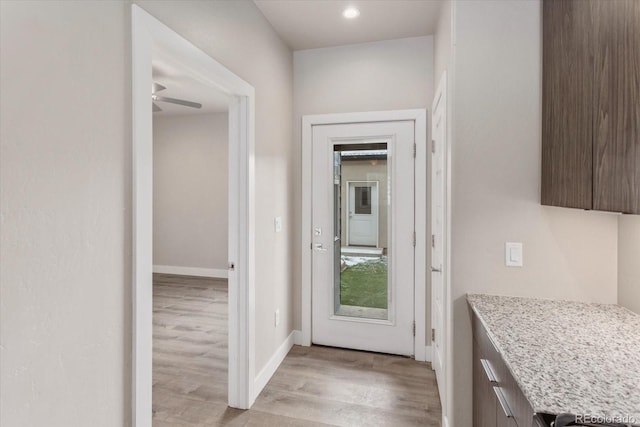 doorway to outside featuring light wood-style flooring and baseboards