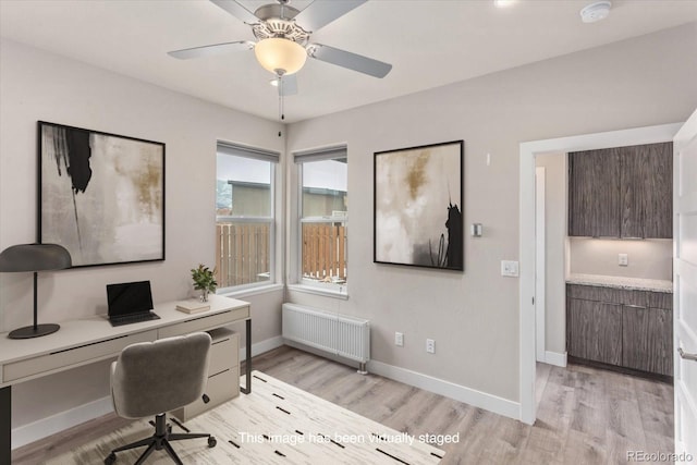 home office with baseboards, light wood finished floors, a ceiling fan, and radiator