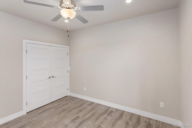 empty room featuring light wood-style floors, ceiling fan, and baseboards