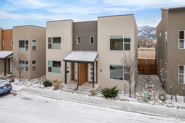 view of front of home with a mountain view, a standing seam roof, metal roof, and stucco siding