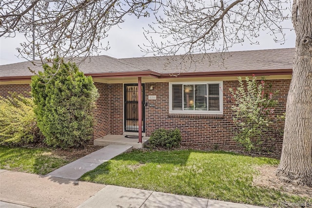 5184 E Asbury Ave, Denver, CO 80222 - view of front of property featuring brick siding, a front lawn, and a shingled roof