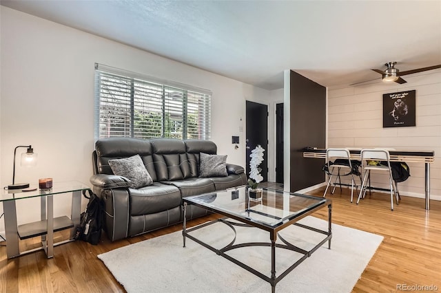 5184 E Asbury Ave, Denver, CO 80222 - living area featuring light wood-style floors, ceiling fan, wood walls, and baseboards