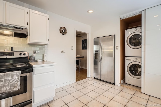 5184 E Asbury Ave, Denver, CO 80222 - kitchen with appliances with stainless steel finishes, stacked washer / drying machine, under cabinet range hood, white cabinetry, and light tile patterned flooring