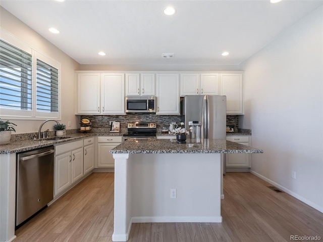 kitchen with white cabinetry, sink, a center island, and appliances with stainless steel finishes