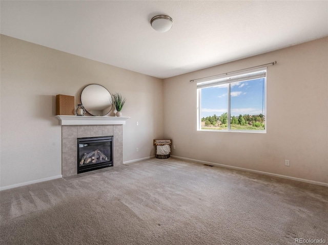 unfurnished living room with carpet floors and a tile fireplace