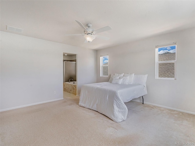 carpeted bedroom with multiple windows, connected bathroom, and ceiling fan