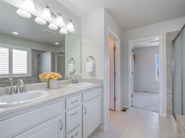 bathroom featuring vanity and a shower with door