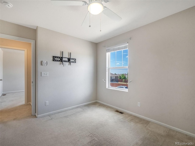 carpeted spare room with ceiling fan