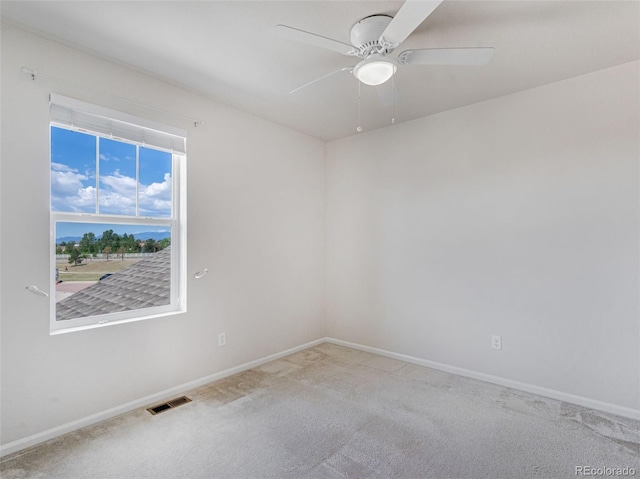 carpeted spare room with ceiling fan