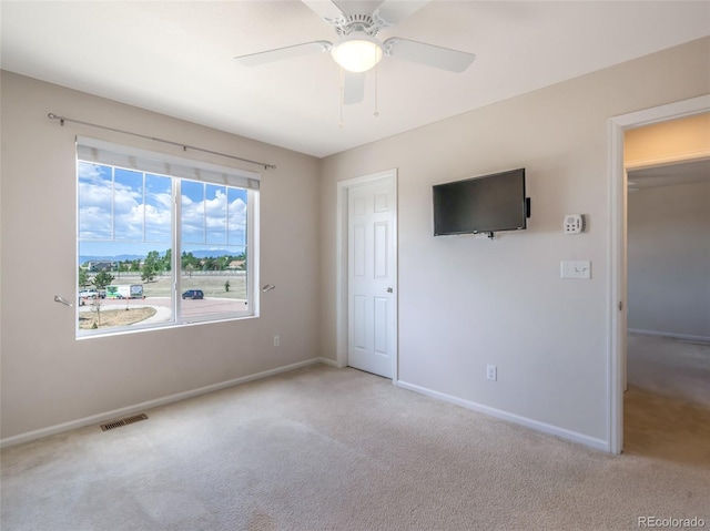 carpeted spare room featuring ceiling fan