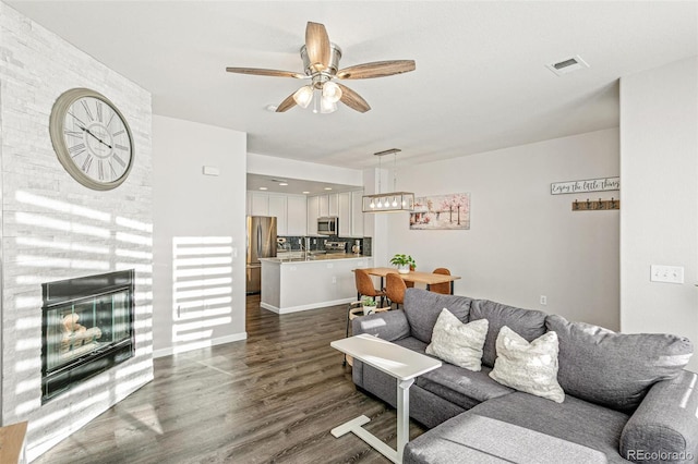 living room with ceiling fan and dark hardwood / wood-style flooring