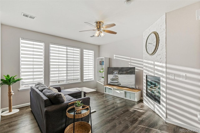 living room with ceiling fan, dark wood-type flooring, and a wealth of natural light