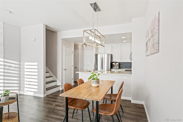 dining space featuring dark wood-type flooring and a chandelier