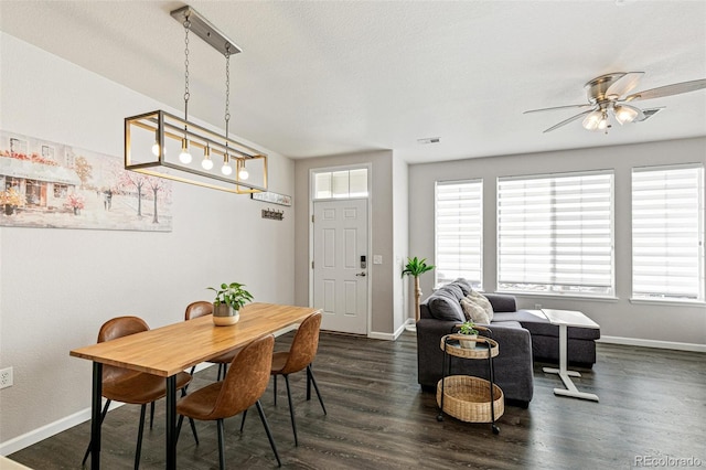 dining space featuring ceiling fan, dark wood-type flooring, and a textured ceiling