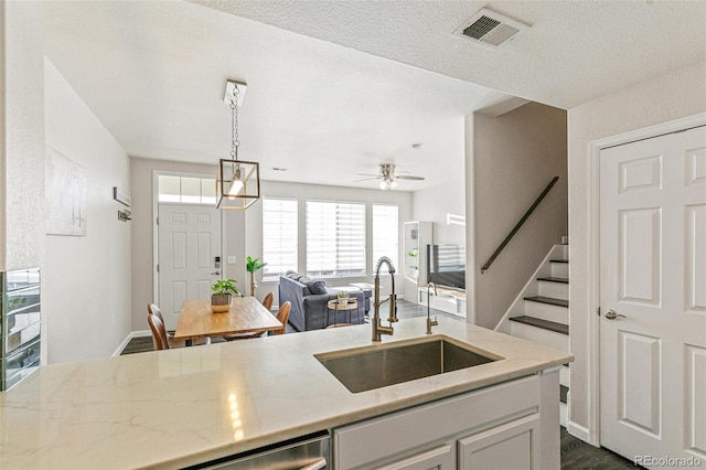 kitchen featuring ceiling fan, decorative light fixtures, sink, white cabinetry, and dark wood-type flooring