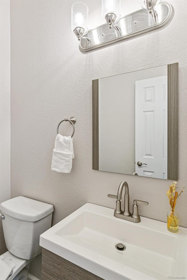 bathroom featuring toilet and vanity