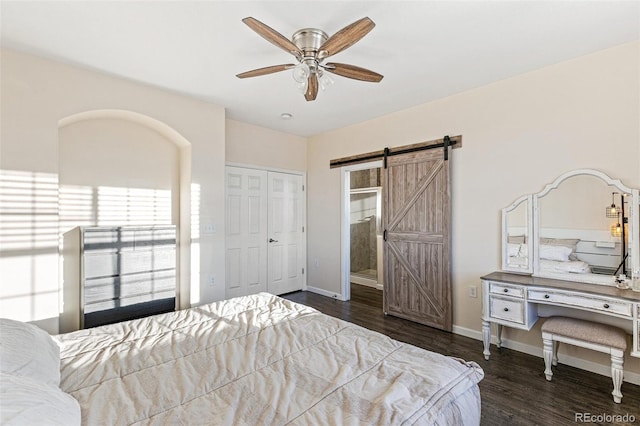 bedroom featuring ceiling fan, dark hardwood / wood-style flooring, a closet, and a barn door