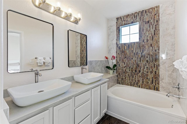 bathroom featuring hardwood / wood-style floors, a bath, and vanity