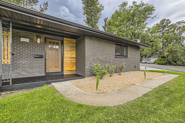 doorway to property with a lawn