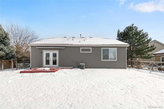 snow covered property featuring cooling unit and french doors