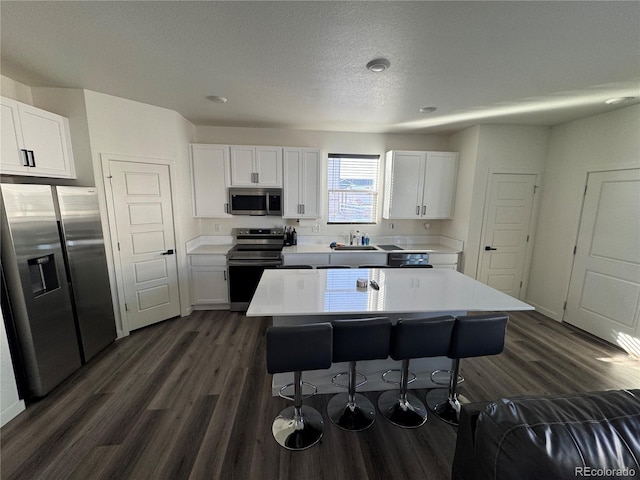 kitchen with stainless steel appliances, a center island, and white cabinets