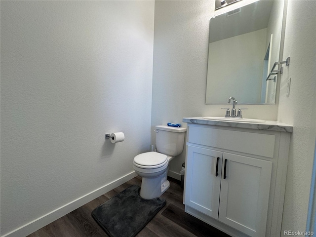 bathroom featuring vanity, hardwood / wood-style floors, and toilet