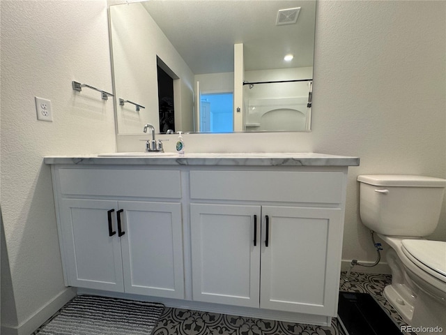 bathroom with vanity, a shower, and toilet