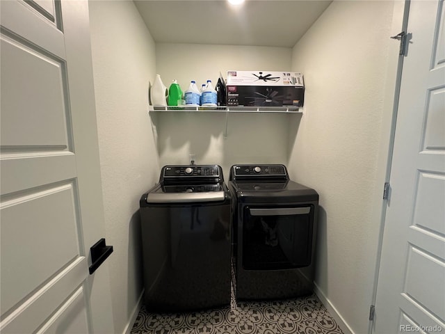 clothes washing area featuring washer and clothes dryer and light tile patterned floors