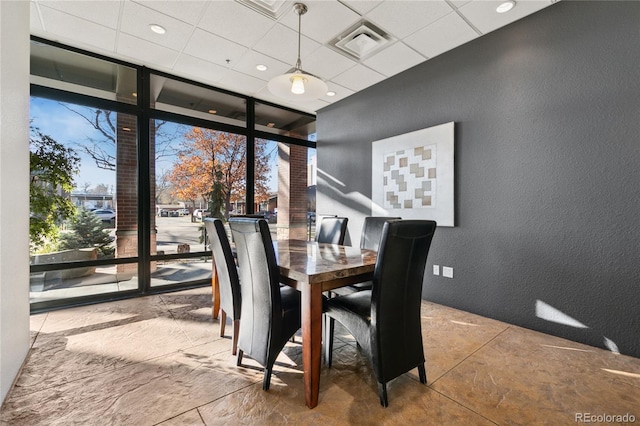 dining room featuring a paneled ceiling and a wall of windows