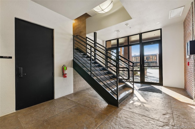 interior space with floor to ceiling windows and brick wall