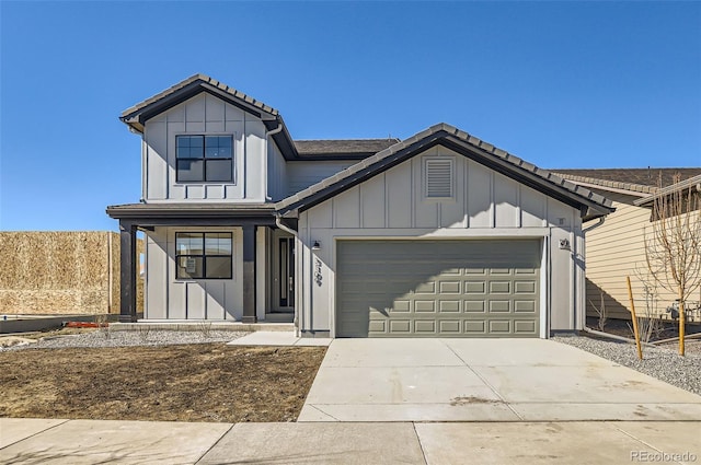 view of front of home with driveway, a garage, board and batten siding, and a tiled roof