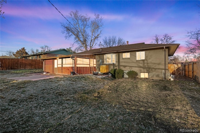 rear view of house with a patio area, a fenced backyard, and brick siding