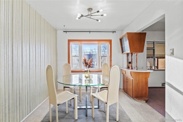 dining area with carpet and a chandelier