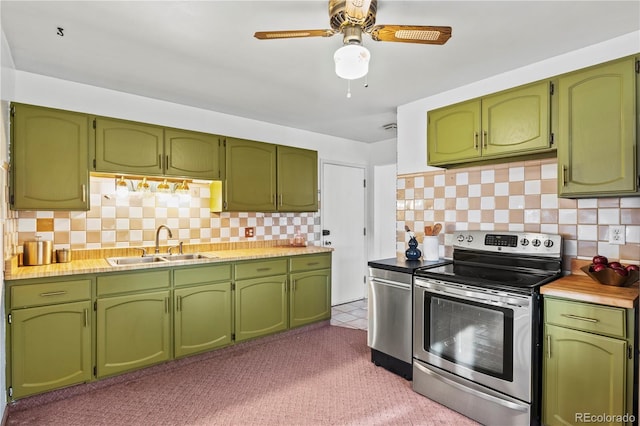 kitchen with green cabinets, stainless steel electric range, backsplash, and a sink