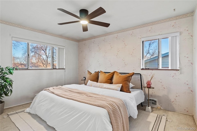 carpeted bedroom featuring wallpapered walls and ceiling fan