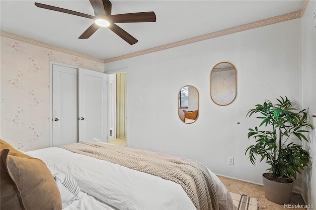 bedroom featuring wallpapered walls, ceiling fan, and light carpet