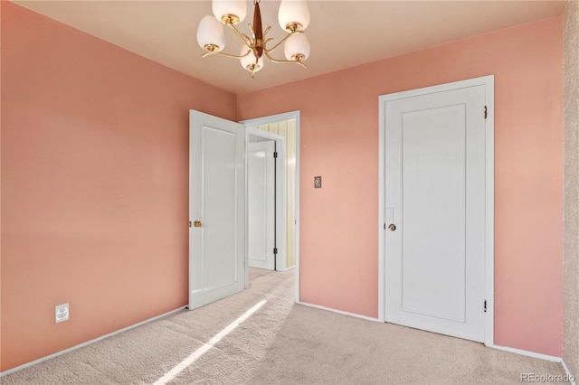 unfurnished bedroom featuring an inviting chandelier, baseboards, and carpet