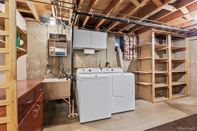 laundry room featuring cabinet space, washing machine and dryer, and a sink