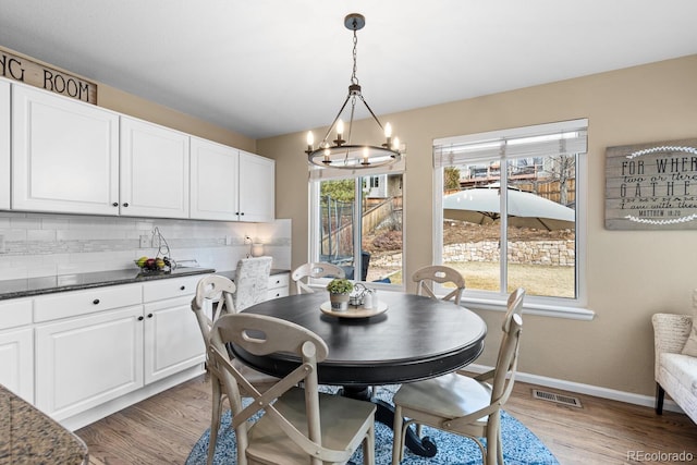 dining room with hardwood / wood-style floors, a chandelier, and a healthy amount of sunlight